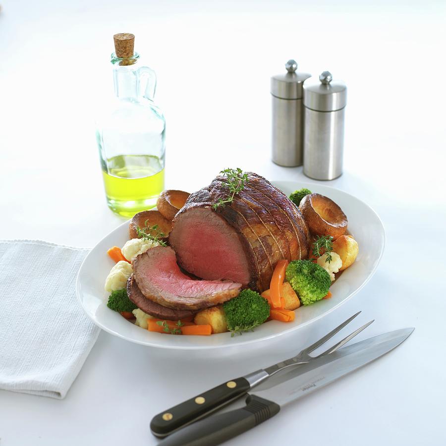 A Joint Of Roast Beef With Vegetables And Yorkshire Puddings Photograph by Robert Morris