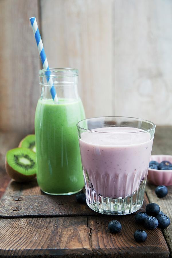 A Kale And Apple Smoothie In A Glass Bottle And A Blueberry And Banana Smoothie In A Glass Photograph by Victoria Firmston