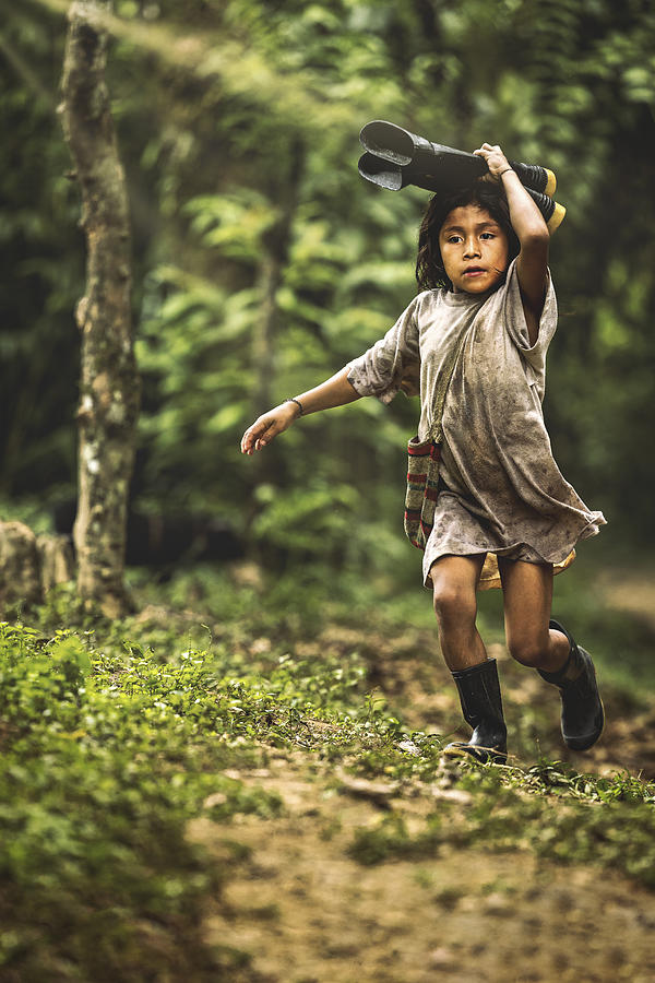 A Kid Is Running While Holding Boots Photograph by Milton Louiz