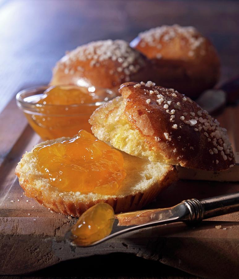 A Knife Next To A Brioche, Sliced Open, With Coarse Sugar Crystals And Apricot Jam Photograph by Ludger Rose