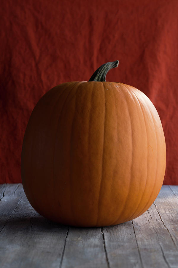A Large Halloween Pumpkin On A Wooden Surface Photograph by Eising Studio
