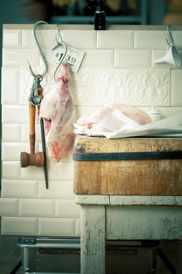 A Leg Of Pork On A Hook And A Goose On A Wooden Board In A Butchers Shop Photograph by Jalag / Wolfgang Schardt