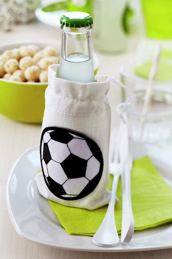 A Lemonade Bottle In A Small Fabric Bag With A Football Decoration Photograph by Franziska Taube
