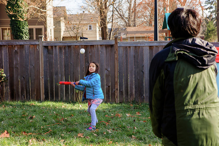 Softball Photograph - A Little Girl Plays Softball With Father In Backyard In Winter by Cavan Images / Rebecca Tien