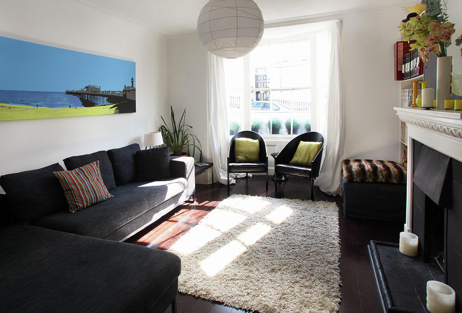 A Living Room With Black Seats, A Beige Flokati Rug And A Fireplace Photograph by Steven Morris