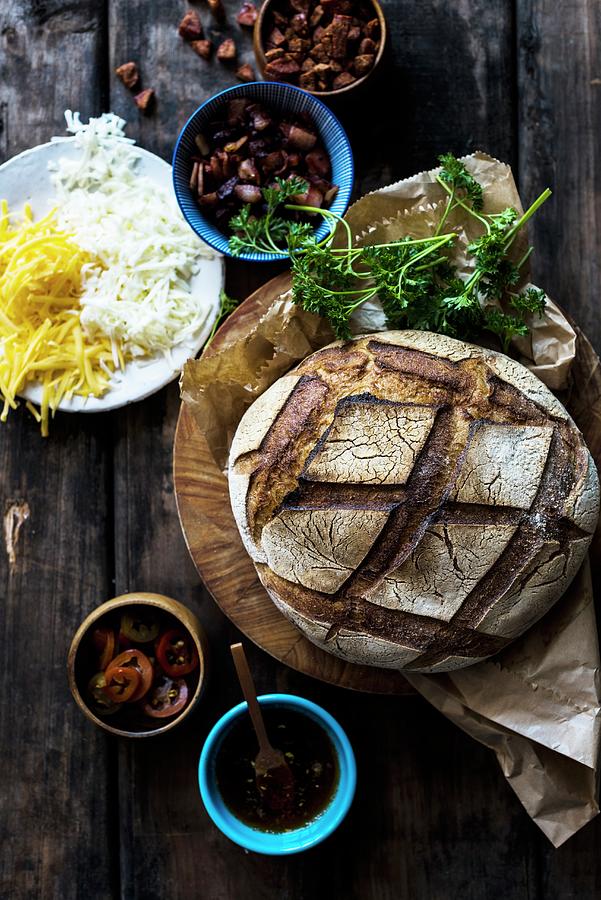 A Loaf Of Dark Sourdough Bread With Ingredients For Sandwiches Photograph by Hein Van Tonder