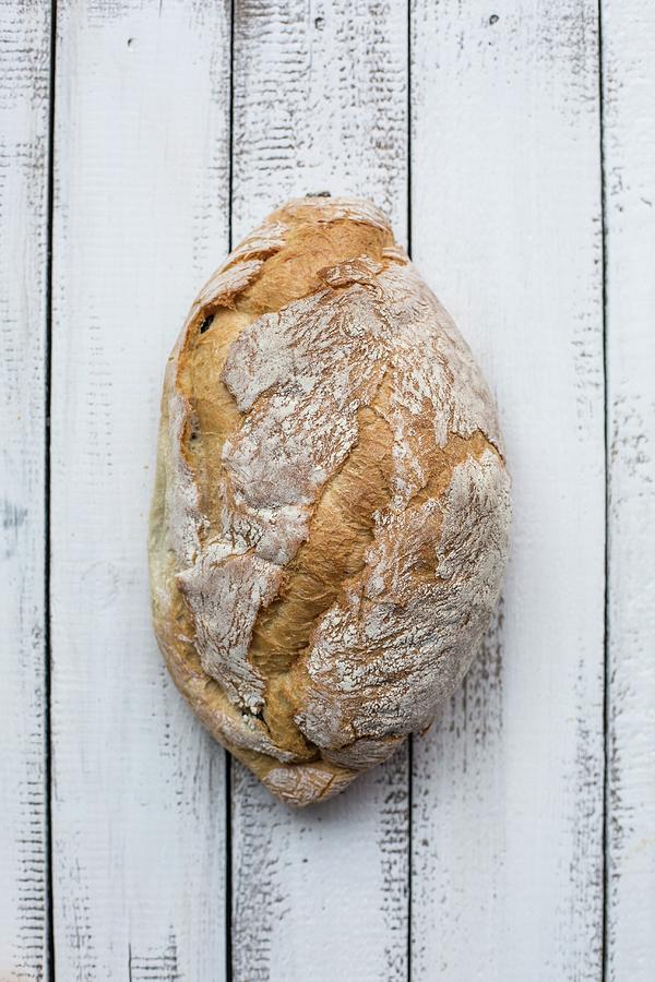 A Loaf Of Rustic Bread On A Wooden Surface Photograph by Sabine Steffens