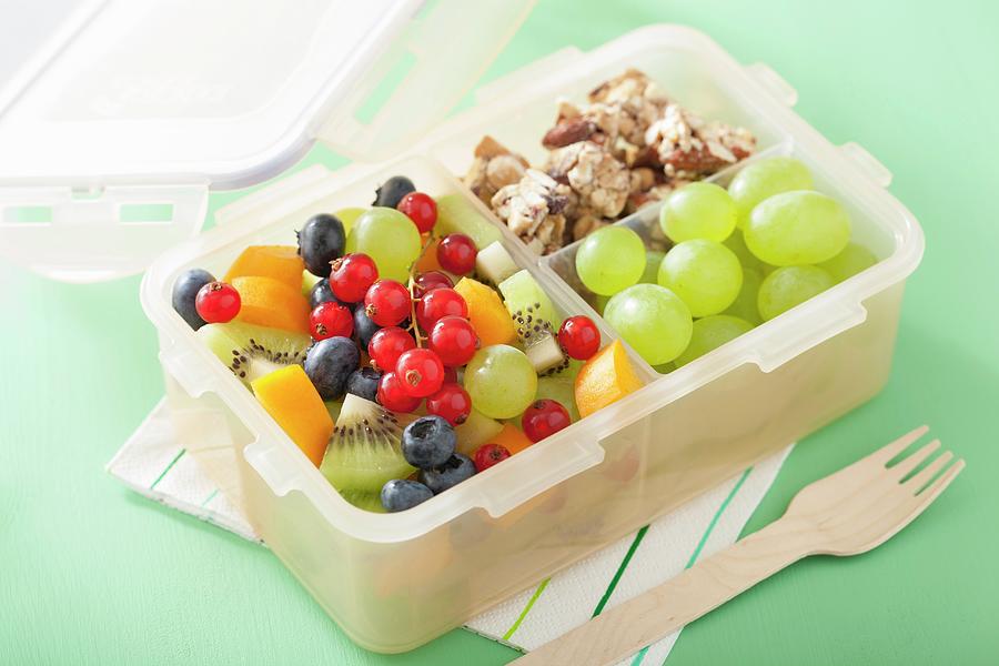 A Lunch Box With Fruit Salad And Nut Bars Photograph by Olga Miltsova