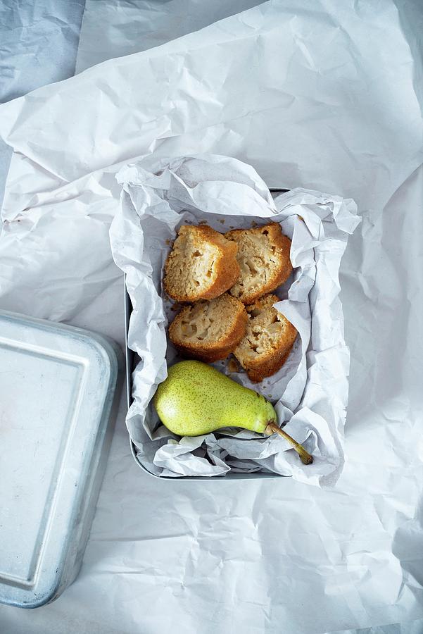A Lunchbox Containing A Pear And Four Pieces Of Vegan Pear Cake Made Of Spelt And Cornflour, Sweetened With Coconut Blossom Sugar Photograph by Kati Neudert