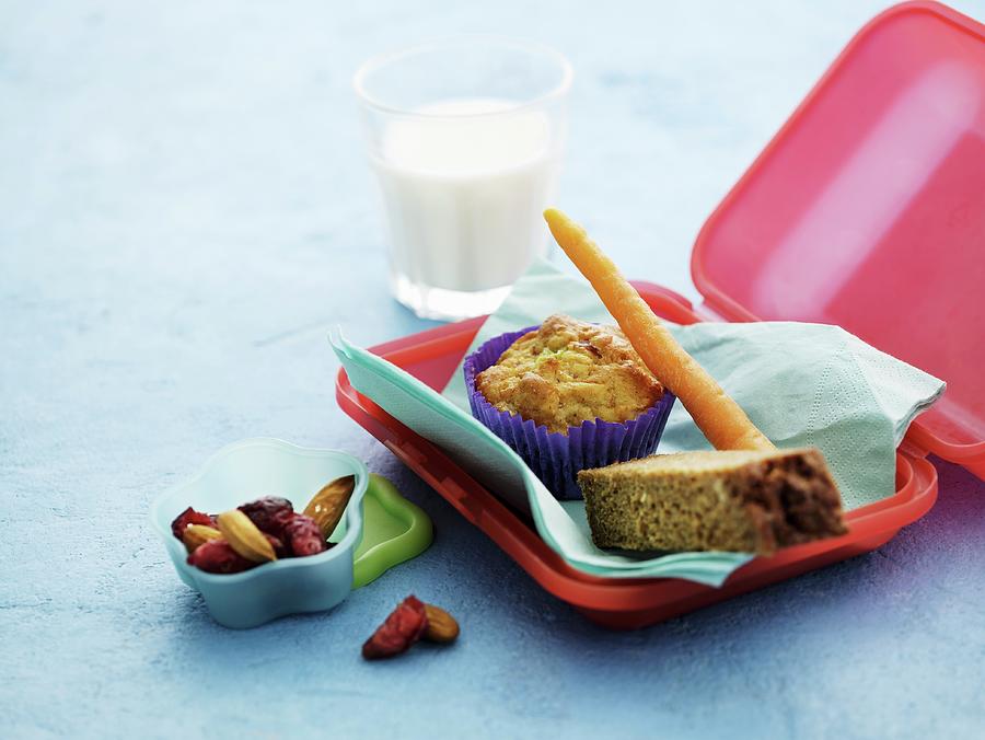 A Lunchbox With A Muffin, Carrots, Bread, Dried Fruits And Milk Photograph by Mikkel Adsbl
