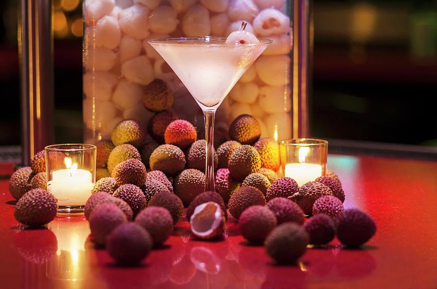 A Lychee Martini Between Tea Lights And Surrounded By Fresh Lychees Photograph by Don Crossland