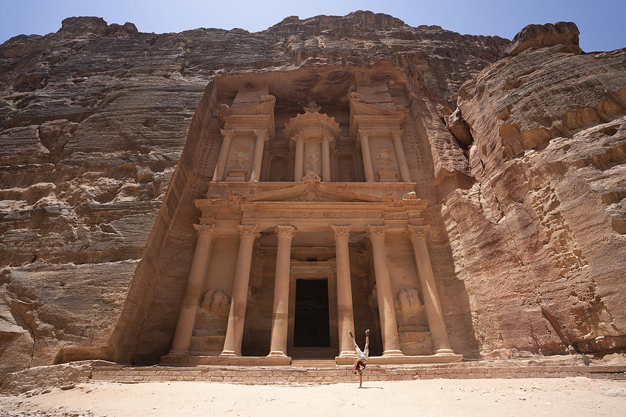 Architecture Photograph - A Man Does A Hand Stand Near Treasury Monument In Petra, Jordan Seven Wonders by Cavan Images