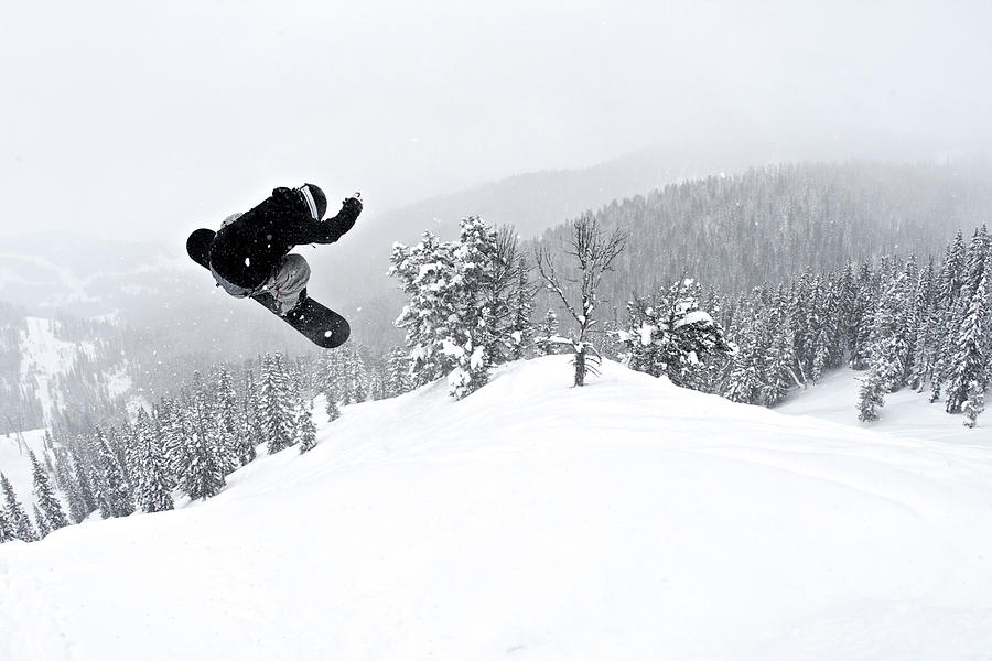A Man On A Snowboard Flies Through The Photograph by Derek Diluzio