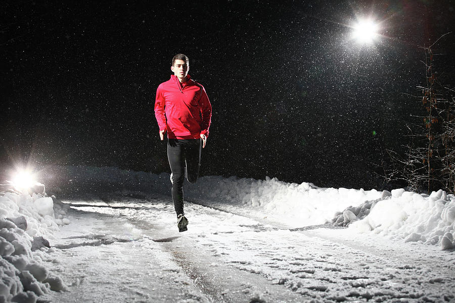 A Man Running At Night On Snowy Forest Photograph by Stanislaw Pytel