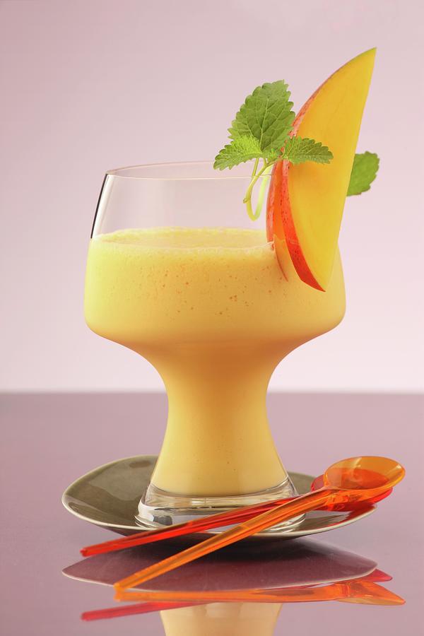 A Mango And Carrot Lassi With Lemon Balm Photograph by Uwe Bender