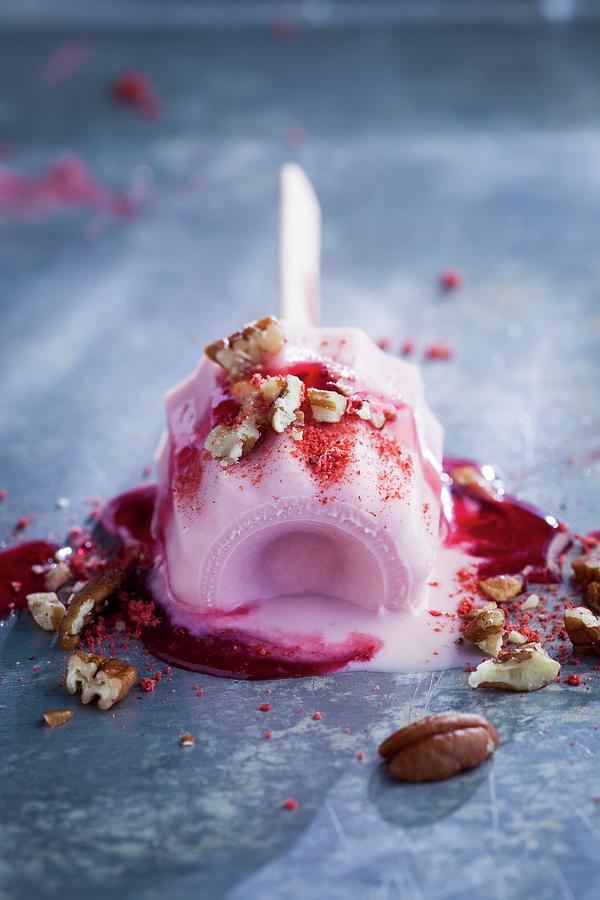 A Melting Strawberry Ice Cream On A Stick, Topped With Chopped Pecans Photograph by Eising Studio