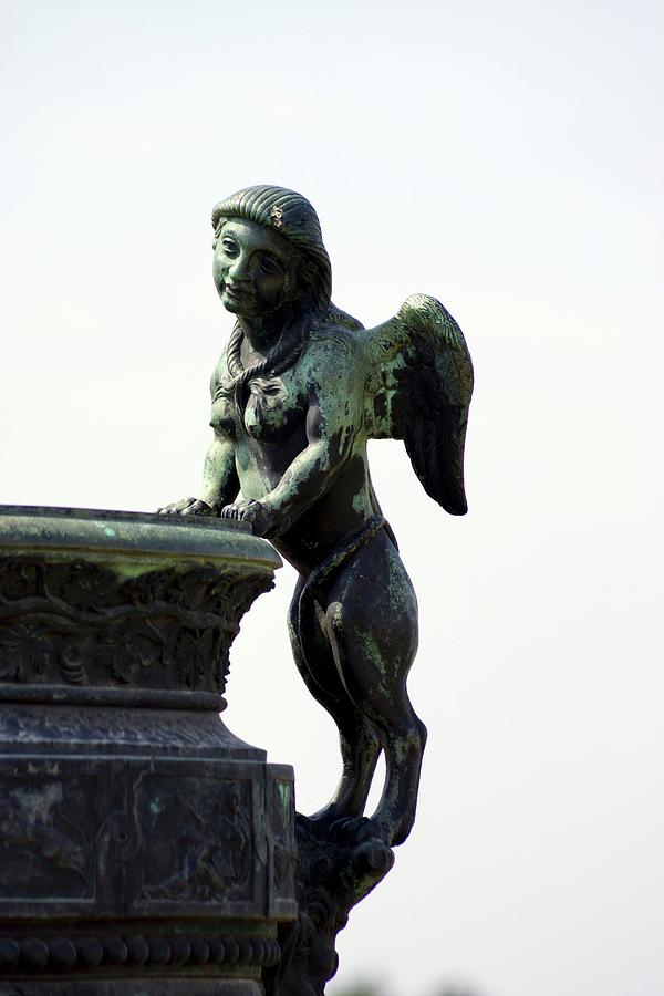 A Metal Figure With Wings In The Garden Of The Palace Of Versailles Photograph by Angelica Linnhoff