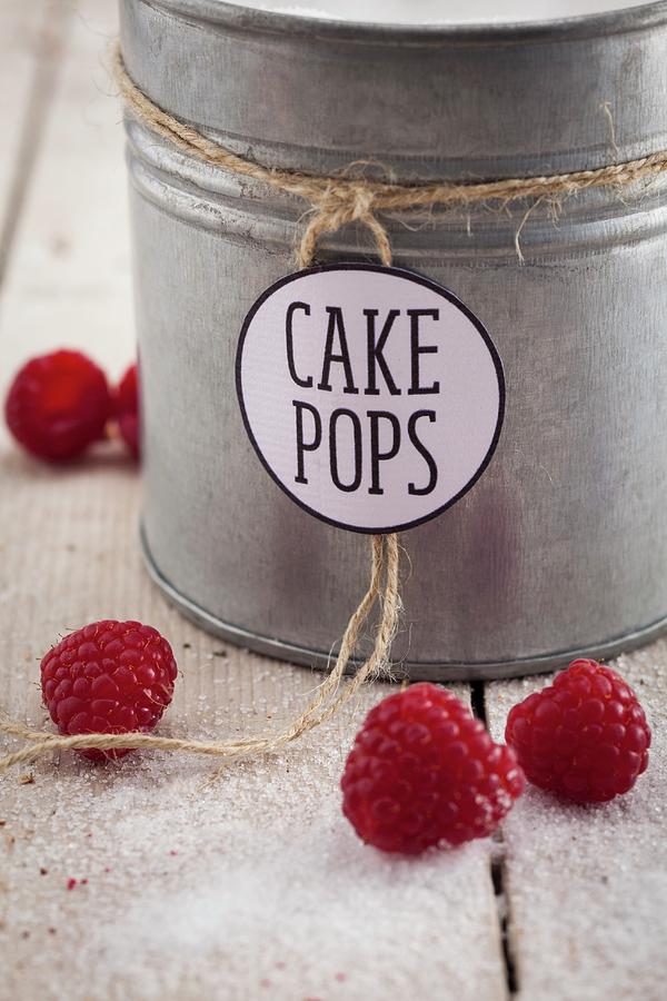 A Metal Tin Of Sugar For Cake Pops With Raspberries Photograph by Eising Studio - Food Photo & Video