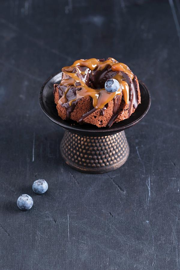 A Mini Cake With Chocolate Glaze, Caramel Sauce And Blueberries Photograph by Mandy Reschke