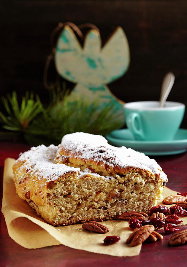 A Mini Cranberry And Pecan Nut Stollen For Christmas On Baking Paper In Front Of A Cup Of Coffee Photograph by Teubner Foodfoto
