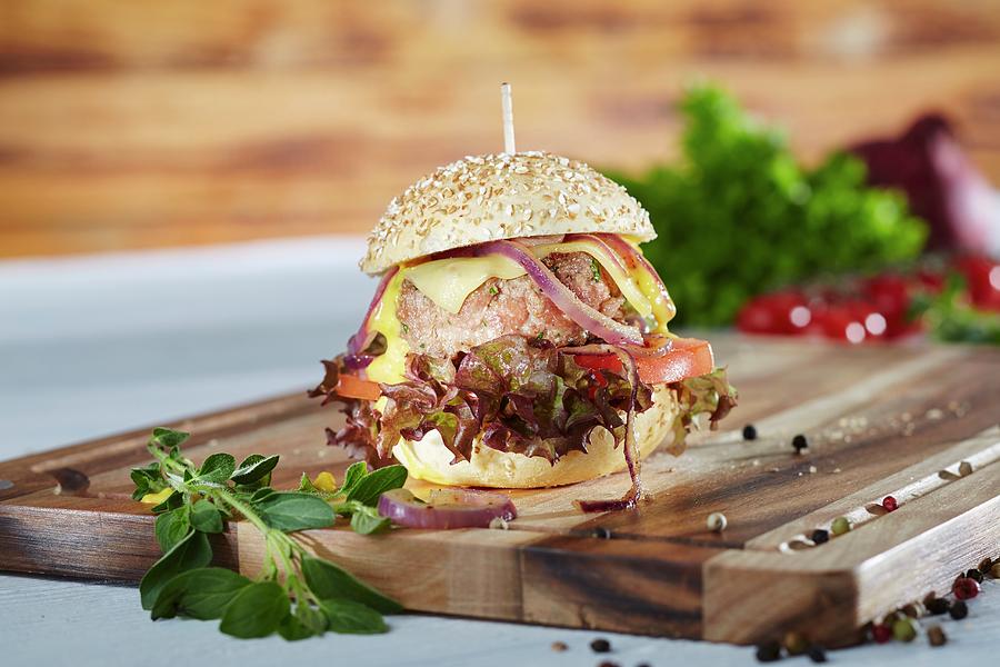 A Mini Hamburger With Oak Leaf Lettuce, Tomatoes, Onions And Cheese Photograph by Niklas Thiemann