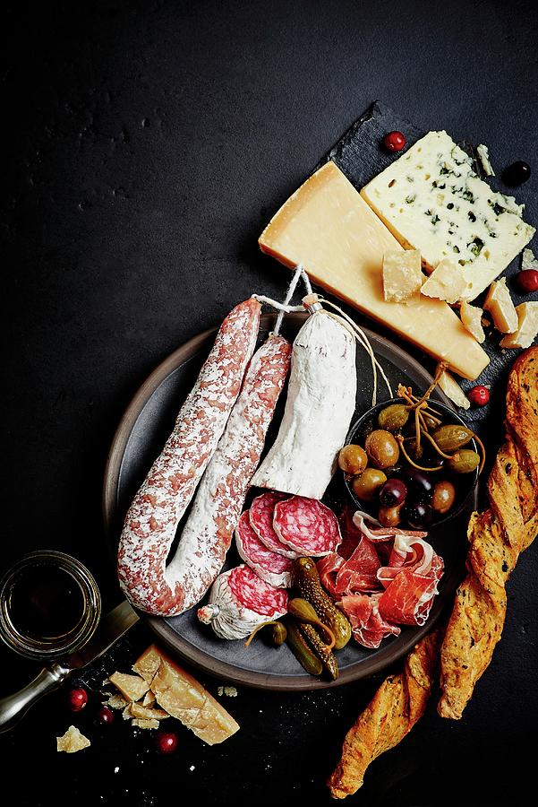 A Mixed Antipasti Platter With Olives, Capers, Prosciutto, Dried Sausage, Salami, Grissini, Parmesan And Blue Cheese Photograph by Egle Ma