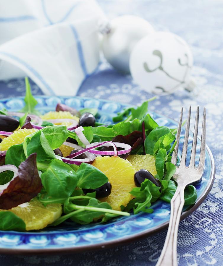 A Mixed Leaf Salad With Orange Slices, Olives And Bermuda Onions