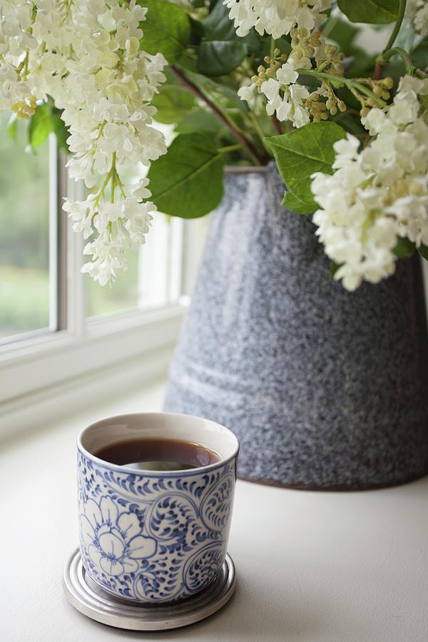 A Mug Of Tea In Front Of A Bunch Of Lilac Flowers In A Ceramic Mug Photograph by Ryla Campbell
