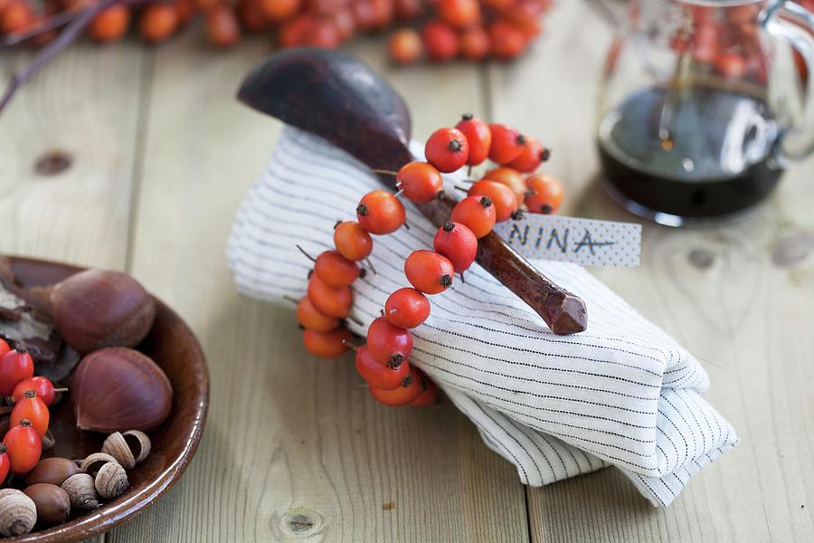 A Napkin And A Wooden Spoon Wrapped With A Rosehip Wreath With A Nametag Photograph by Martina Schindler