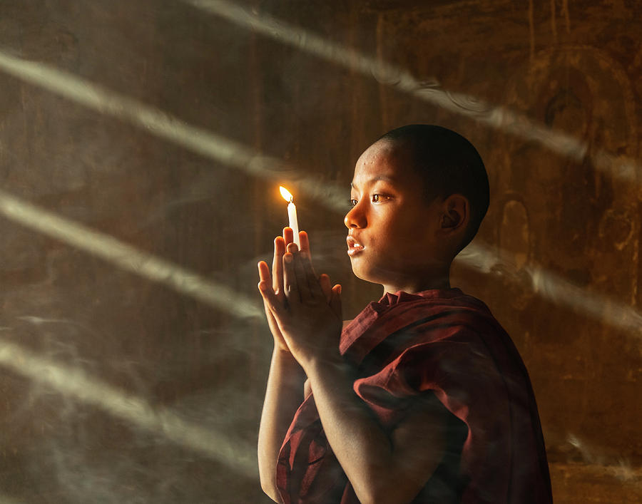 A Novice Monk With Candle In Prayer In Temple Photograph by Ann Moore