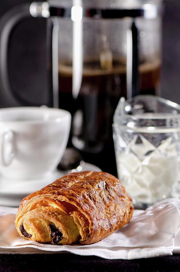 A Pain Au Chocolat With A Coffee Cup And A Coffee Machine In The Background france Photograph by Jamie Watson