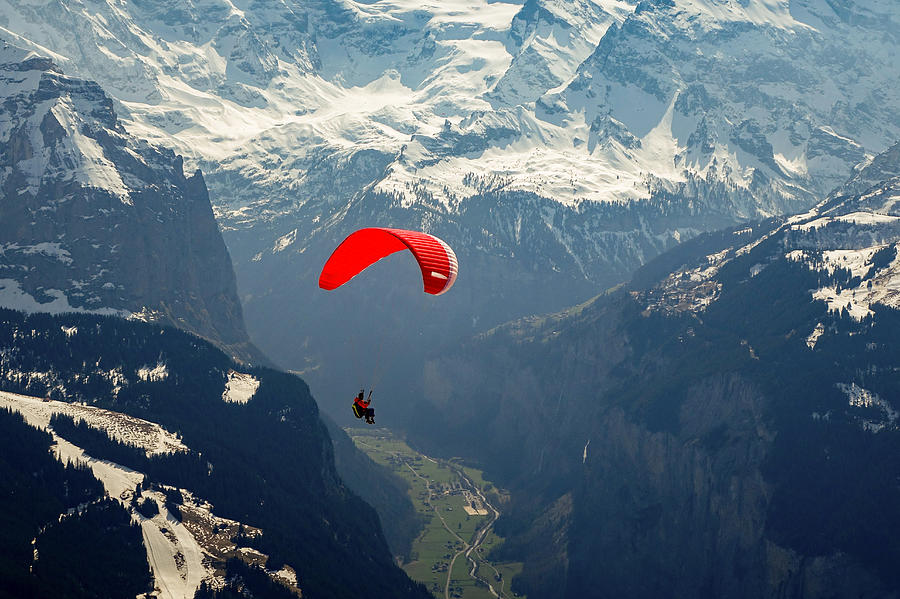Mountain Photograph - A paraglider flying high above Lauterbrunnen valley in Switzerland. by George Afostovremea