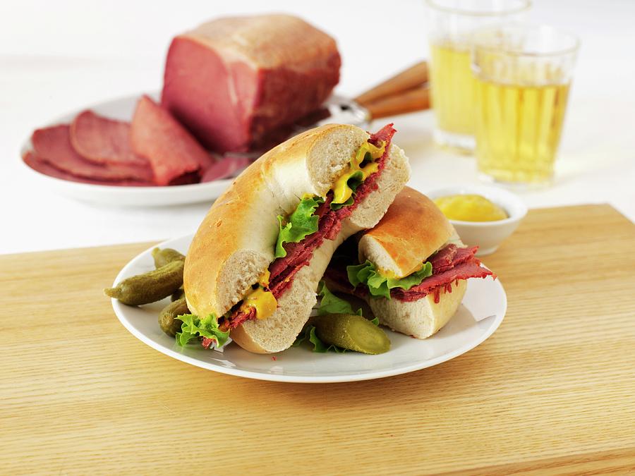 A Pastrami, Salad And Mustard Bagel Served With Gherkins Photograph by Frank Adam