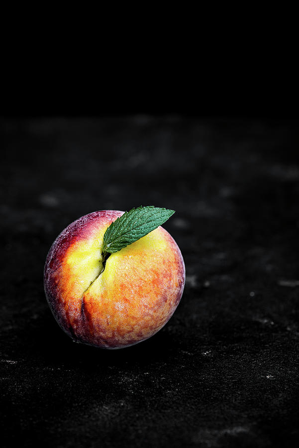 A Peach With A Leaf On A Dark Background Photograph by M. Nlke