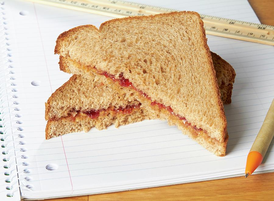 A Peanut Butter And Jam Sandwiches On A Notebook Photograph by Allison Dinner