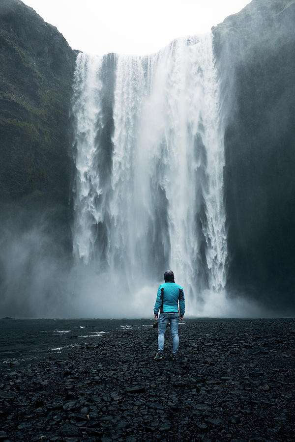 Nature Photograph - A person admirnig the beauty of Skogafoss waterfall located in Iceland by Mattia Riccadonna