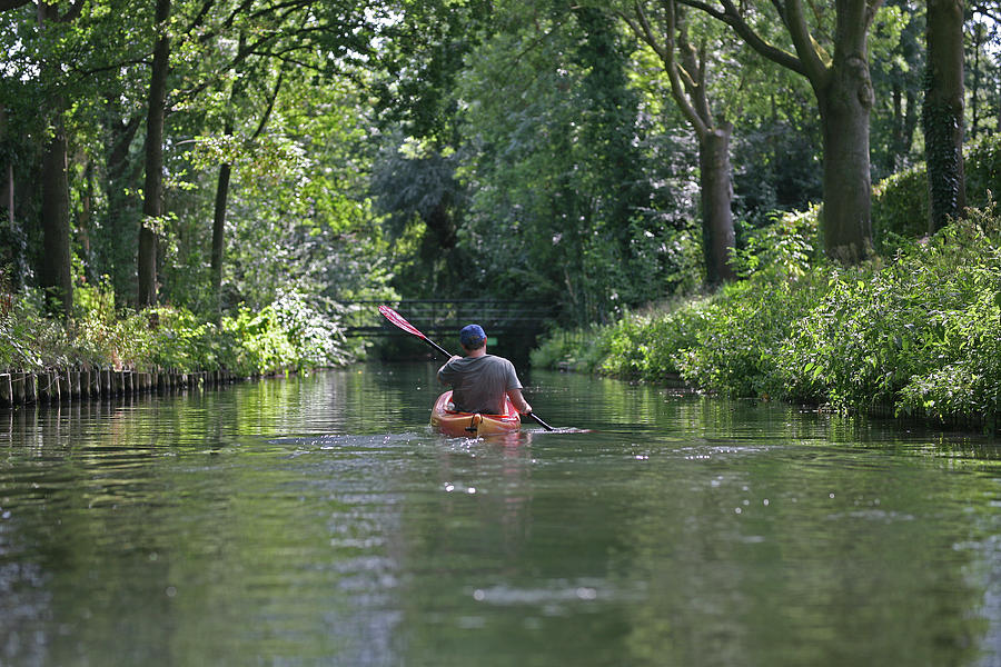 Nature Photograph - A Person Kayaking Along A Canal In The Countryside Of Utrecht by Cavan Images