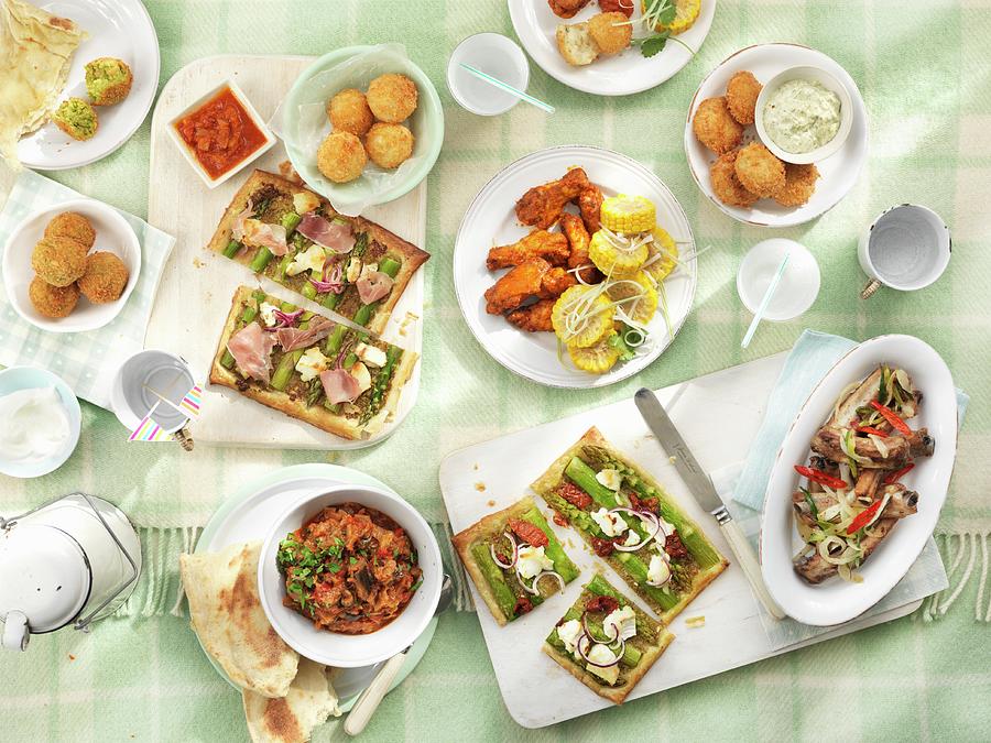 A Picnic Featuring Rice Balls, Spicy Chicken Wings, Fish Balls, Ratatouille, Ribs, Vegetable Tart, Unleavened Bread And Falafel Photograph by Jonathan Gregson