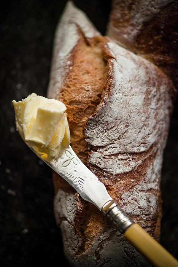 A Piece Of Pain Depi french Baguette Shaped Like An Ear Of Wheat And A Knife With Butter Photograph by Katrin Winner