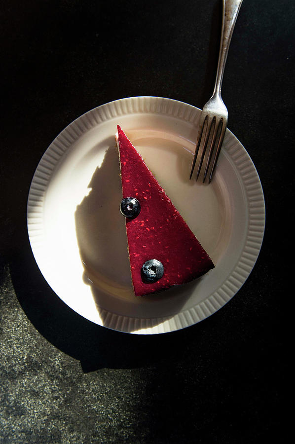 A Piece Of Raspberry Cake With Two Blueberries On A Plate With A Fork Photograph by Olga Berndt