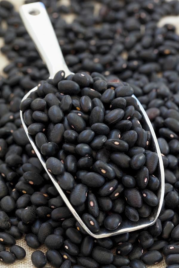 A Pile Of Black Beans With A Metal Scoop Photograph by Lydie Besancon