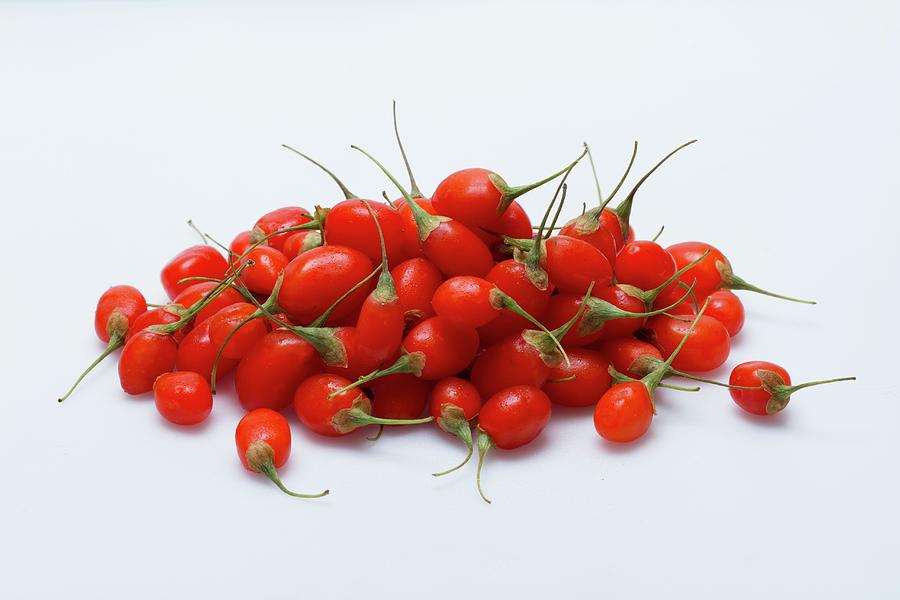 A Pile Of Fresh Goji Berries On A White Surface Photograph by Eising Studio