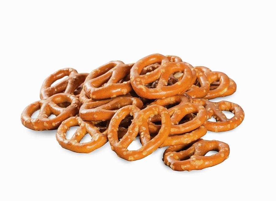 A Pile Of Mini Salted Pretzels On A White Surface Photograph by Colin Cooke