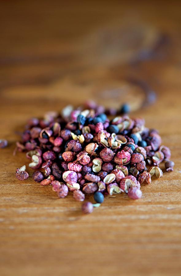 A Pile Of Szechuan Peppercorns On A Wooden Table Photograph by Jamie Watson
