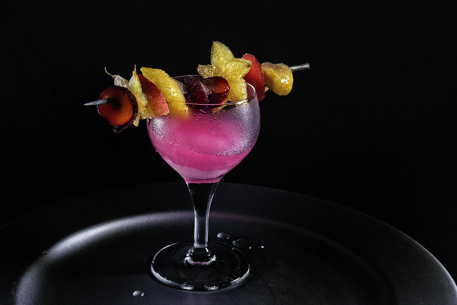 A Pink Drink With An Exotic Fruit Skewer Photograph by Kaktusfactory