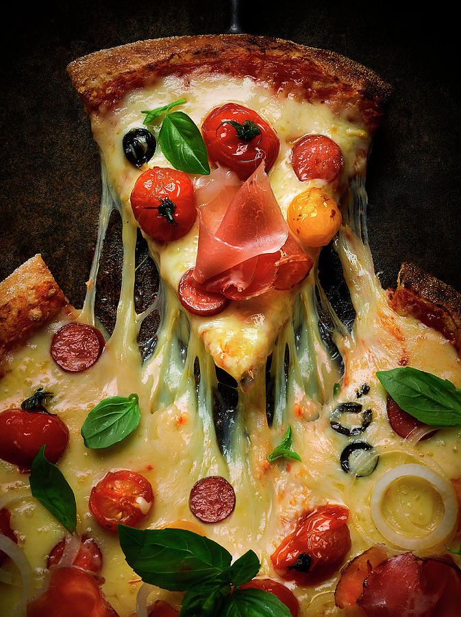 A Pizza Topped With Salami, Ham, Tomatoes, Olives And Cheese Photograph by Vadim Piskarev