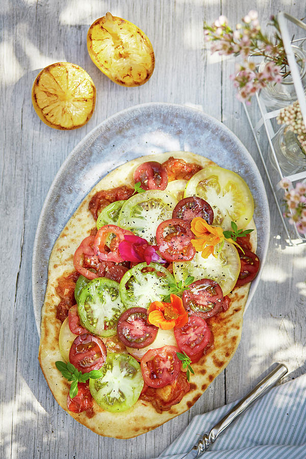 A Pizza With Colourful Tomatoes On A Summery Outdoor Table Photograph by Winfried Heinze