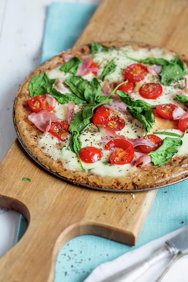 A Pizza With Ham, Spinach And Tomatoes Photograph by Claudia Timmann