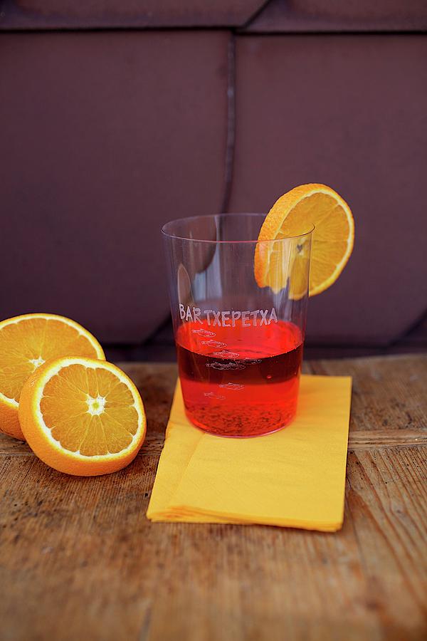 A Plastic Cup Of Campari With A Slice Of Orange Photograph by Sophia Schillik