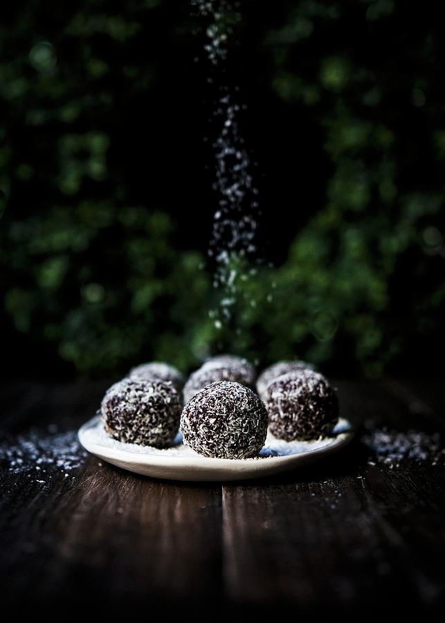 A Plate Of Spiced Chocolate Brownie Rum Balls Rolled In Coconut Flakes Photograph by Lisa Rees